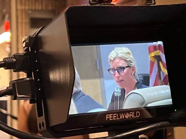 Britt Riner, a member of the board of directors of Sarasota Memorial Hospital, is seen on the screen of a TV camera filming a board meeting in Sarasota, Fla., on Feb. 21, 2023. (Chris Nelson/The Epoch Times)