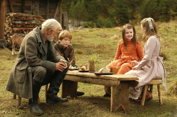 (L–R) Grandfather (Max von Sydow), Peter (Sam Friend), Heidi (Emma Bolger), and Clara (Jessica Claridge) share a meal in the mountains. (MovieStillsDB)
