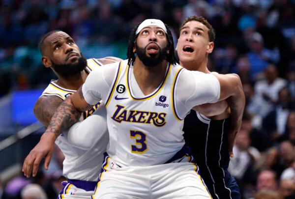 Anthony Davis (3) and teammate LeBron James (6) of the Los Angeles Lakers box out Dwight Powell (7) of the Dallas Mavericks for a rebound in the first half at American Airlines Center in Dallas on Feb. 26, 2023. (Ron Jenkins/Getty Images)