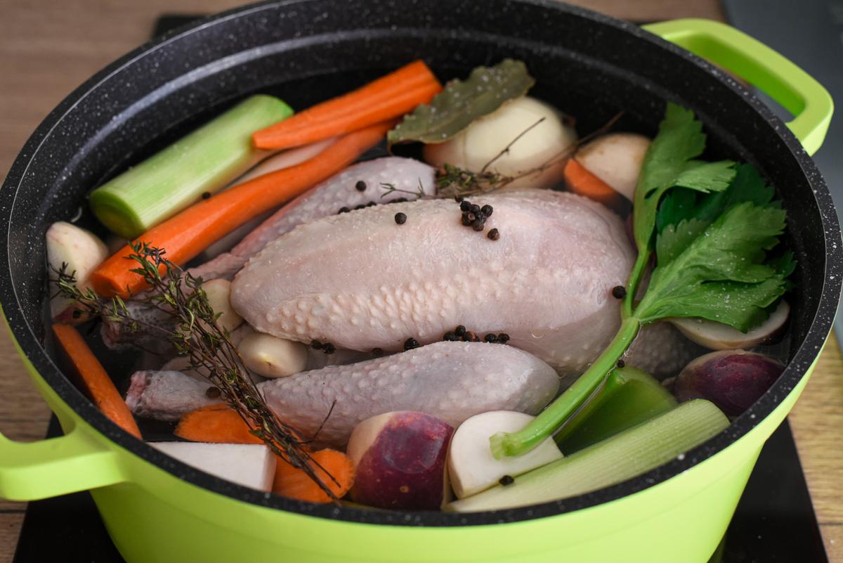 Bring the chicken to a boil, skimming the foam off the top. Then add the vegetables, herbs, and spices. (Audrey Le Goff)