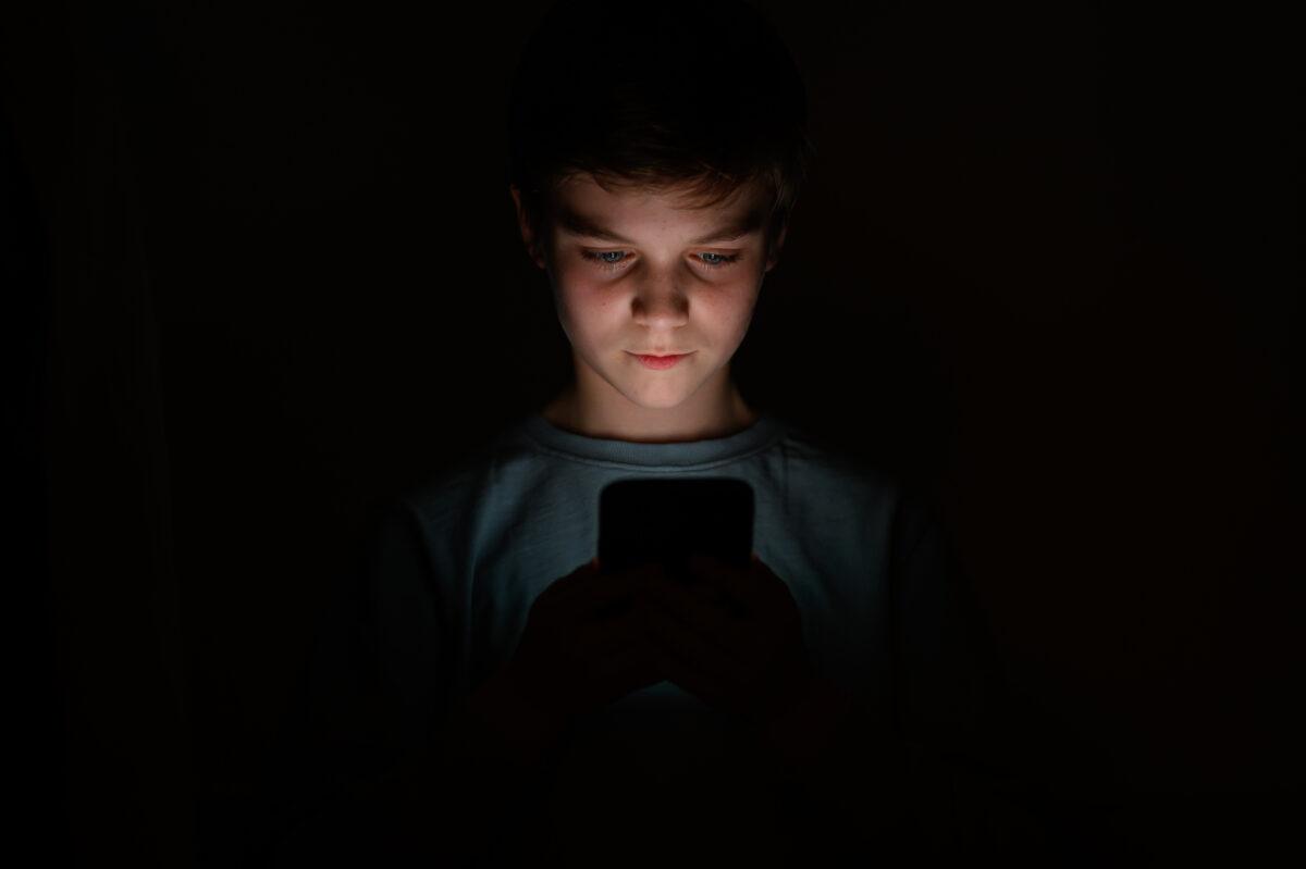 A teenage child looks at the screen of a mobile phone in London on Jan. 17, 2023. (Leon Neal/Getty Images)