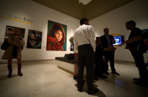 Visitors look at the iconic National Geographic photo of the Afghan girl at Rome's Palazzo delle Esposizioni in 2013. (Filippo Monteforte/AFP via Getty Images)