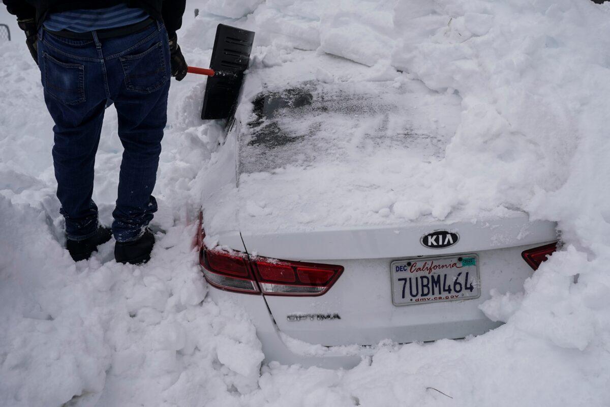 Kenny Rybak, 31, shovels snow around his car in Running Springs, Calif., on Feb. 28, 2023. (Jae C. Hong/AP Photo)