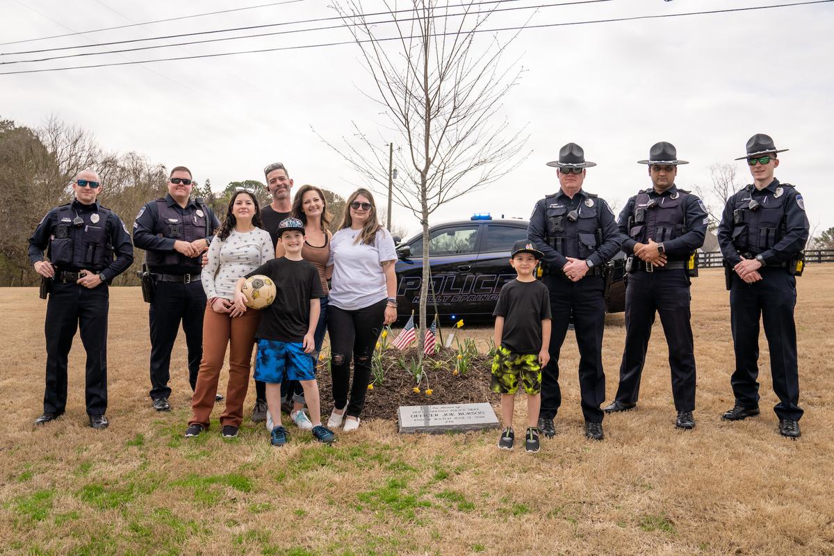 The Chancer family and members of Officer Joe Burson's police department stand beside his memorial. (Courtesy of Holly Springs Police Department)