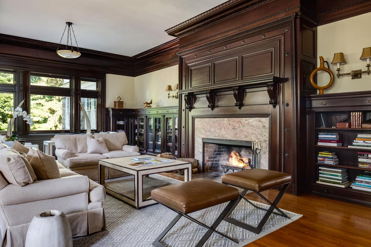 The living room of the main residence is an ideal place to gather with family and friends to enjoy the warmth of the brick and marble fireplace and marvel at the millwork crafted by skilled artisans. (Daniel Milstein for Sotheby’s International Realty)