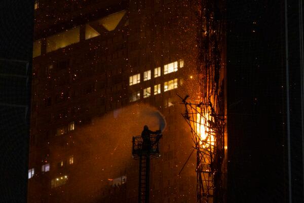 A firefighter sprays water onto a fire in Hong Kong on March 3, 2023. (Louise Delmotte/AP Photo)