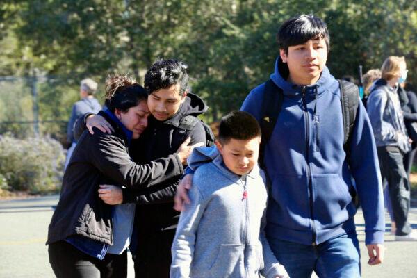 Ana Canul embraces her eldest son Viktor, 17, while her son, Marko, 15, walks with his little brother, Karlos, 10, after the two elder children were released from the lockdown at Montgomery High School in Santa Rosa, Calif., on March 1, 2023. (Beth Schlanker/The Press Democrat via AP)