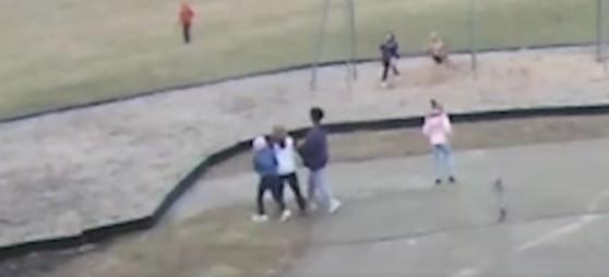A screenshot from video released by Springfield, Ohio, School District showing two black students at Kenwood Elementary School forcibly escorting a white student to an area near the swings on the school playground. (Springfield School District)