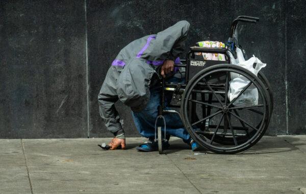 A homeless man sits passed out in San Francisco on Feb. 23, 2023. (John Fredricks/The Epoch Times)