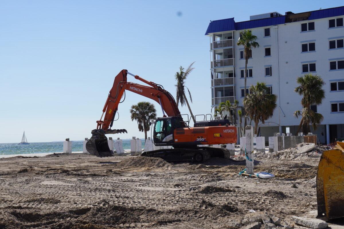 A steam shovel clears the last of debris from a beachfront lot on Fr. Myers Beach, Fla., on Feb. 26, 2023. (John Haughey/The Epoch Times)