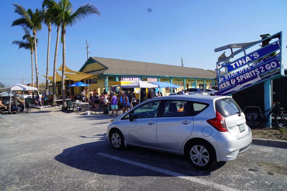 Despite being closed inside, Hurricane Tina's 5-Star Dive Bar on San Carlos Island near the Matanzas Pass Bridge has served as a de facto community center with parties, live music, and meals served in its parking lot from a "pop-up" bar salvaged from debris. (John Haughey/The Epoch Times)