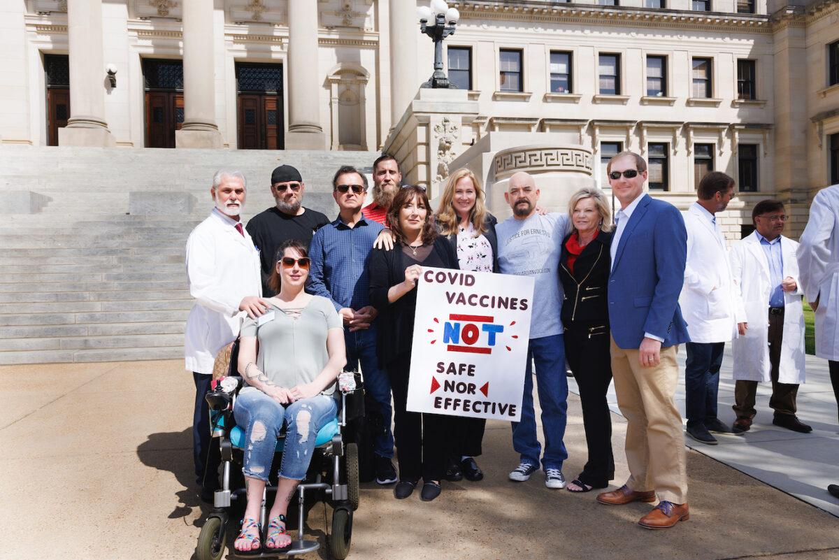 On the steps of the Mississippi Capitol building, Dr. John Witcher (back L) stands with people who have either been injured by or have had family members die from the COVID-19 vaccine, in Jackson, Miss., on Feb. 28, 2023. (Courtesy of Charlotte Stringer Photography)