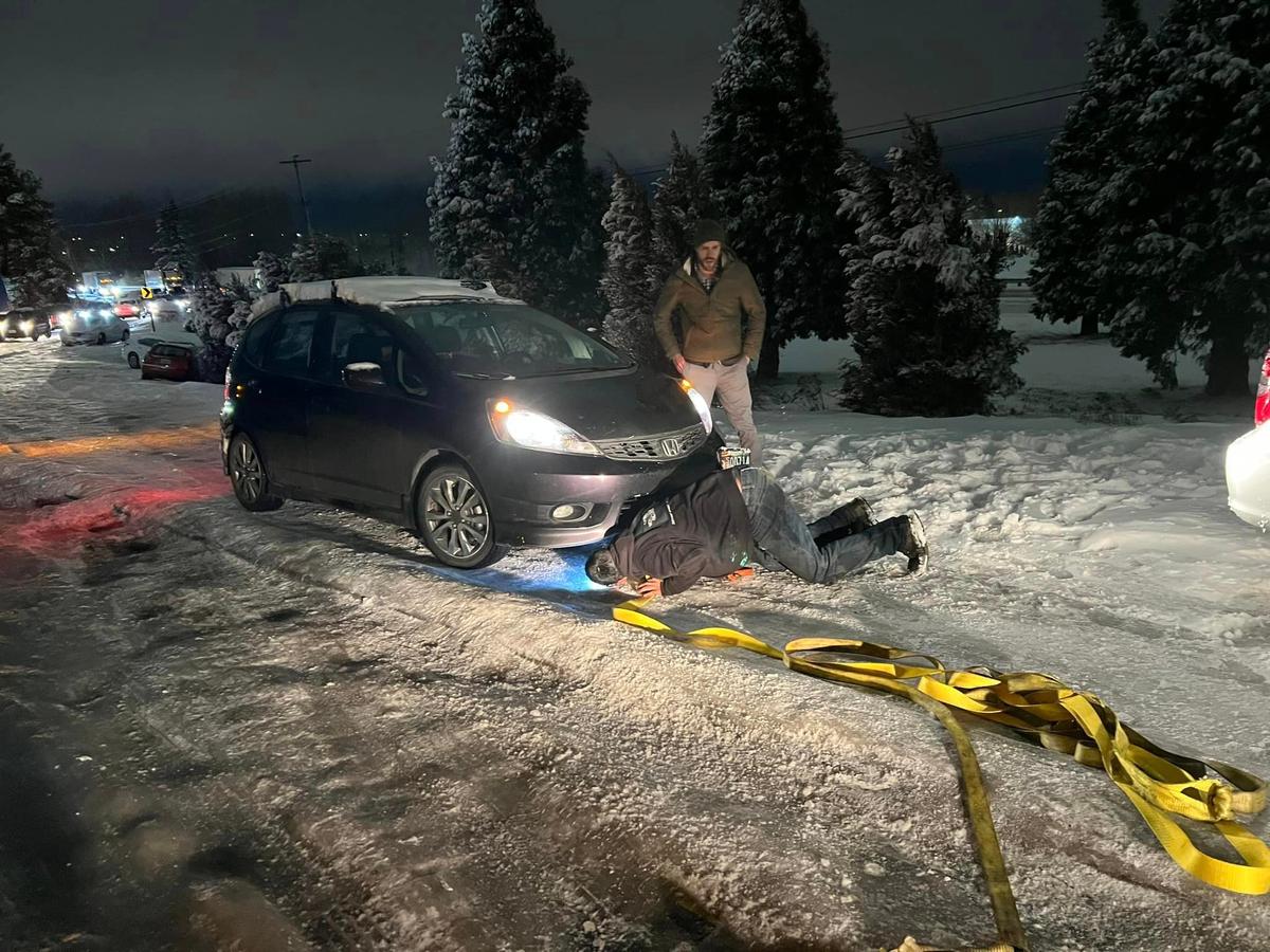 Gilbert helps a motorist stuck on an icy road. (Courtesy of <a href="https://www.facebook.com/alec.higley">Alec Higley</a>)