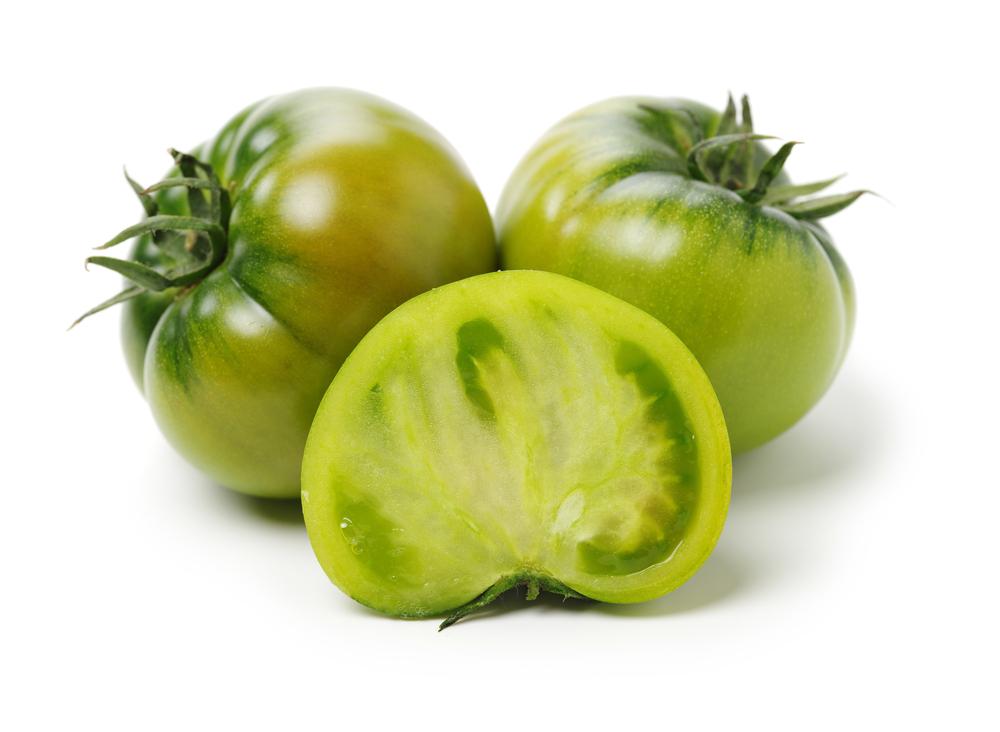To ripen green tomatoes indoors, you can hang the plant upside down in the kitchen or in a heated garage, store the tomatoes wrapped in newspaper, or set the fruits on a shelf in a pantry room. (JIANG HONGYAN/Shutterstock)