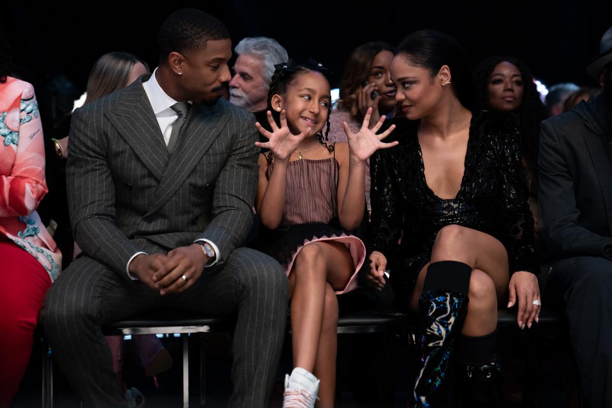 Adonis Creed (director-star Michael B. Jordan), hearing-impaired daughter Amara (Mila Davis-Kent), and wife Bianca (Tessa Thompson) attend a boxing match, in "Creed III." (MGM)