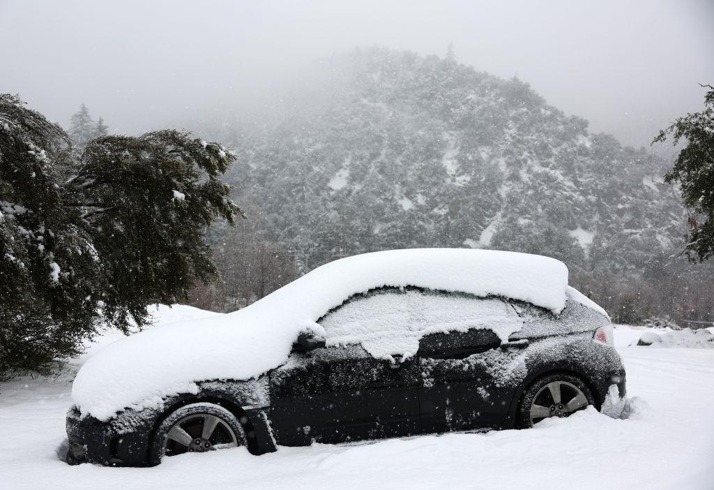 A vehicle is partially covered in snow, in the San Gabriel Mountains in San Bernardino County near Los Angeles County, in Mount Baldy, Calif., on Feb. 24, 2023. (Mario Tama/Getty Images)