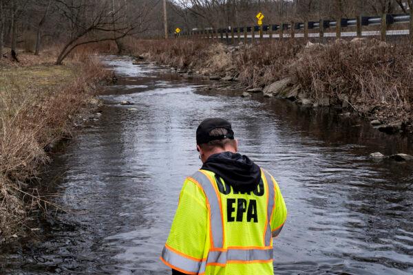 Ron Fodo, Ohio EPA Emergency Response, looks for signs of fish and also agitates the water in Leslie Run creek to check for chemicals that have settled at the bottom following a train derailment in East Palestine, Ohio, on Feb. 20, 2023. (Michael Swensen/Getty Images)