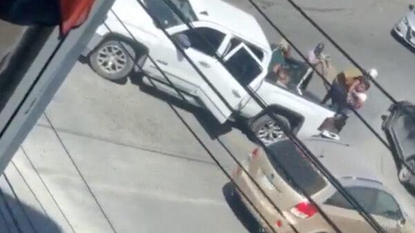 A woman is carried to the back of a white pickup truck in this still image obtained from social media video that allegedly shows the kidnapping of Americans in Matamoros, Mexico, on March 3, 2023. (Video obtained by Reuters)