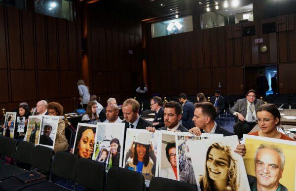 Family members hold photographs of Boeing 737 MAX crash victims lost in two deadly 737 MAX crashes that killed 346 people as they wait for Boeing CEO Dennis Muilenburg to testify before a Senate Commerce, Science and Transportation Committee hearing on “aviation safety” and the grounded 737 MAX on Capitol Hill in Washington on Oct. 29, 2019. (Sarah Silbiger/Reuters)