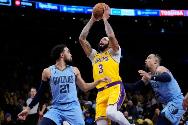 Los Angeles Lakers' Anthony Davis (3) goes up for a basket past Memphis Grizzlies' Tyus Jones (21) and Dillon Brooks (24) during the first half of an NBA basketball game in Los Angeles on March 7, 2023. (Jae C. Hong/AP Photo)