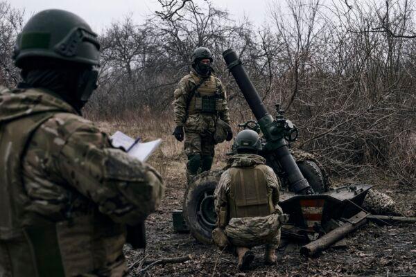 Volunteer Ukrainian soldiers prepare to fire toward Russian positions close to Bakhmut, in the Donetsk region of Ukraine on March 8, 2023. (Libkos/AP Photo)