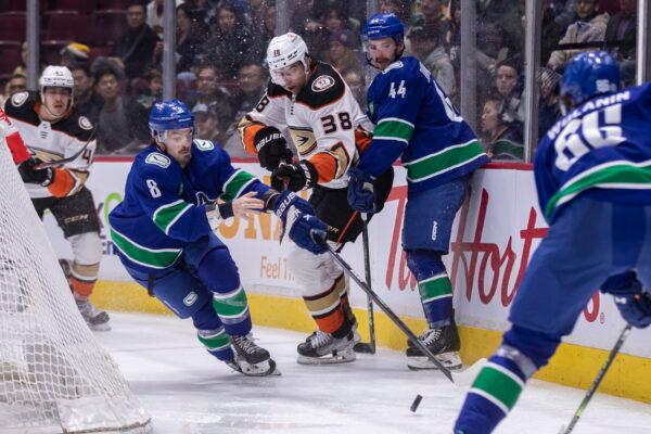 Anaheim Ducks' Derek Grant (38) knocks the glove off of Vancouver Canucks' Conor Garland (8) during the third period of an NHL hockey game in Vancouver, British Columbia, on March 8, 2023. (Ben Nelms/The Canadian Press via AP)