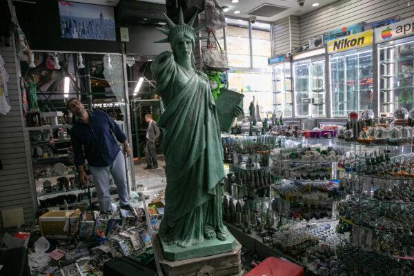 A shop owner looks over damage in a looted souvenir and electronics shop near Times Square after a night of protests and vandalism over the death of George Floyd, in New York, on June 2, 2020. (John Moore/Getty Images)