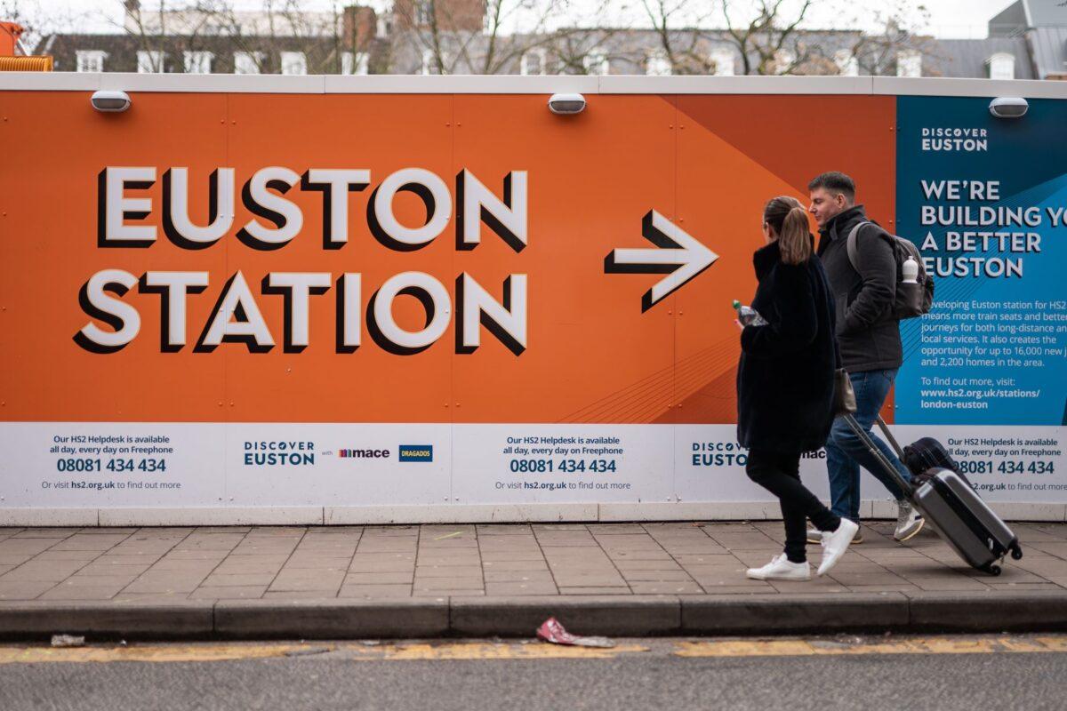 A couple walks past HS2's construction site at Euston in central London on Jan. 27. 2023. (PA)