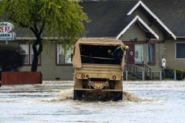 Emergency personal drove through floodwaters in Watsonville, Calif., on March 11, 2023. (Nic Coury/AP Photo)