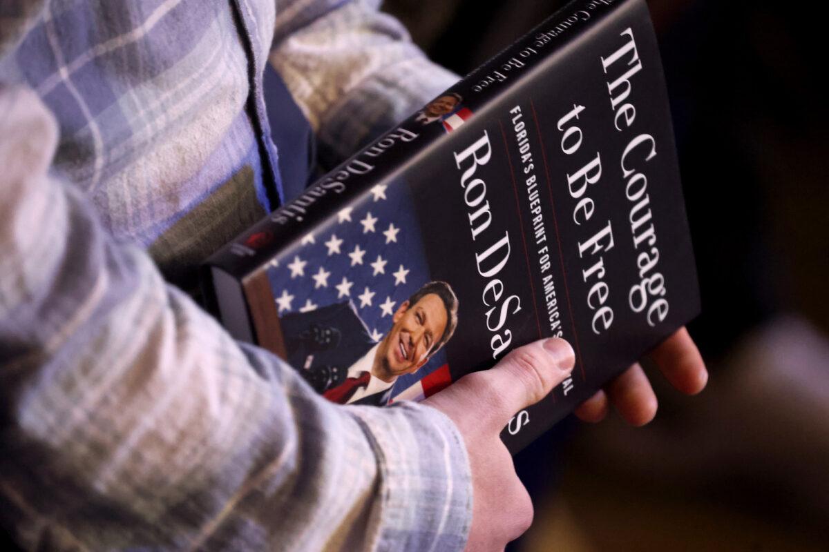 A guest holds a copy of The Courage to be Free by Florida Gov. Ron DeSantis during an event where the governor spoke in Des Moines, Iowa, on March 10, 2023. (Scott Olson/Getty Images)