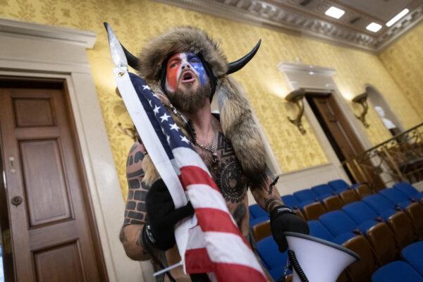 Jacob Chansley, also known as the ‘QAnon Shaman,’ inside the U.S. Senate chamber after the U.S. Capitol was breached on Jan. 6, 2021. (Win McNamee/Getty Images)