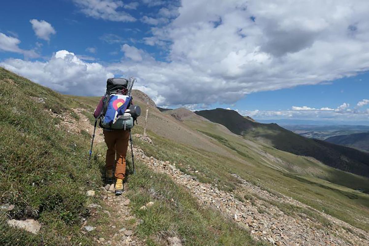 India Wood walked with a Colorado flag as she made her way across the state to its corners. Her she is on a trail in the San Juan Mountains. (Courtesy of India Wood/TNS)