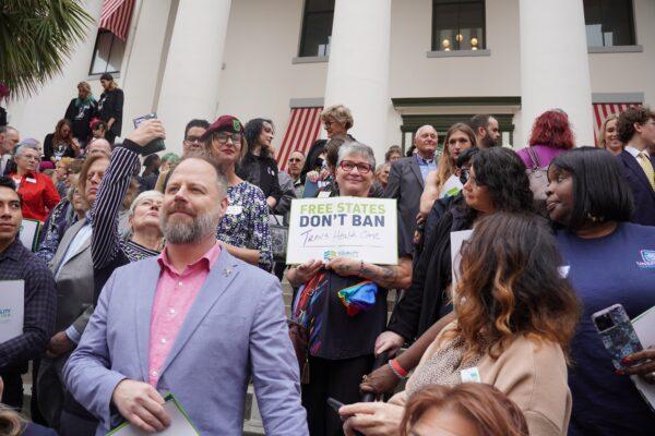 A demonstrator at the Equality Florida rally at the Capitol in Tallahassee, Fla., on March 13, 2023 holds a sign that says "Free States Don't Ban Trans Health Care." (Dan M. Berger/The Epoch Times)
