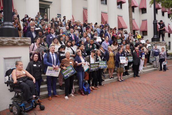 Protestors angry about Florida Gov. Ron DeSantis's vigorous "anti-woke" initiatives pose for a photo at the Florida Capitol in Tallahassee on March 13, 2023. (Dan M.Berger/The Epoch Times)