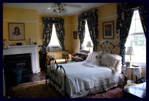 An iron and brass bed and a silk damask settee define the Federal Room, which is appropriately painted yellow since it flows out to an upstairs sun porch with expansive vistas of fields, livestock, and wildlife. This room, like the others at North Bend, is replete with 19th-century antiques. (Courtesy of Michael Johnson)