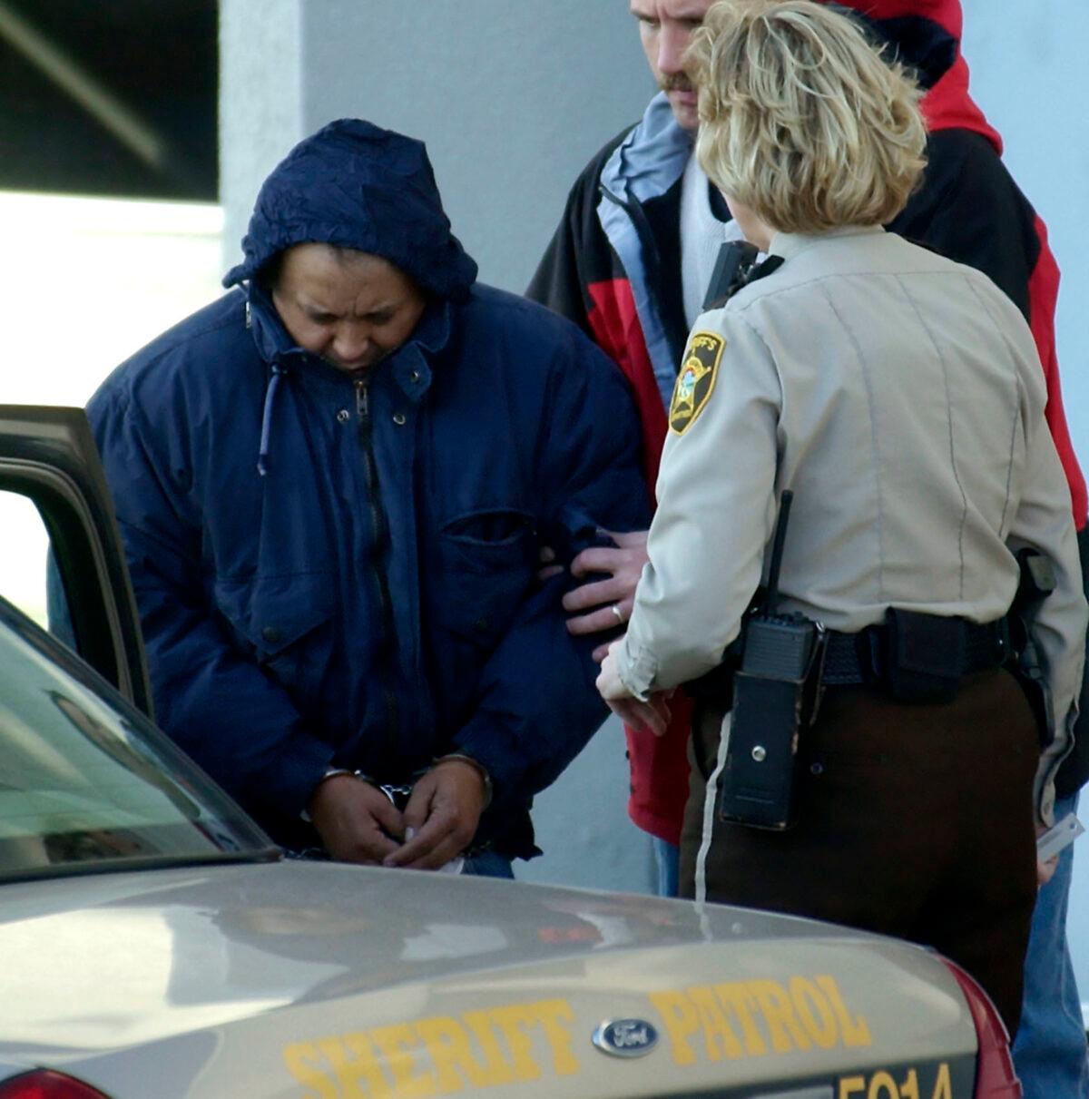 Alfonso Rodriguez Jr. (L) is helped into a sheriff's car after waiving extradition at the Polk County Courthouse in Crookston, Minn., on Dec. 3, 2003. (Ann Heisenfelt/AP Photo)