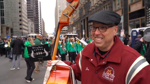 Joe Harris played bass violin at the Quaker City String Band in the St. Patrick’s Day parade on March 12, 2023. (William Huang/The Epoch Times)