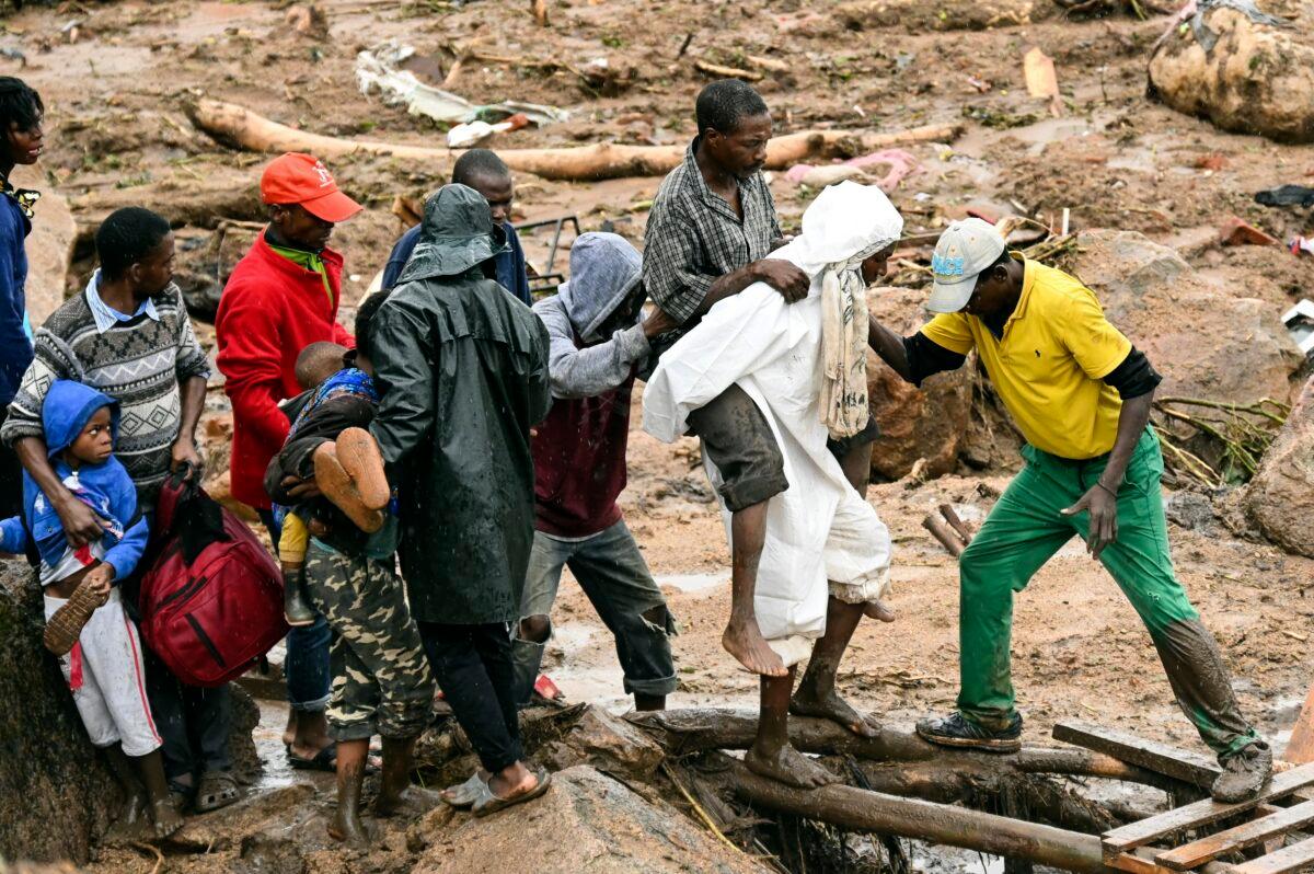 An injured man helped accrossin Blantyre, Malawi, on March 13, 2023. (Thoko Chikondi/AP Photo)