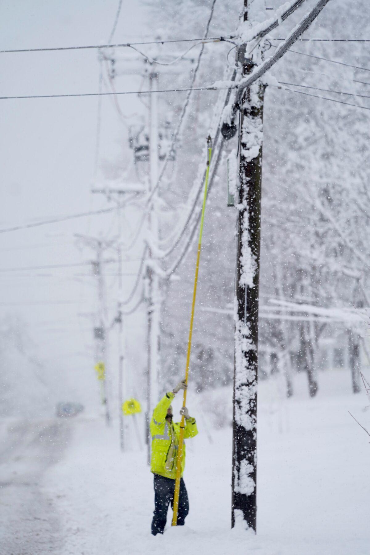 A contractor for Eversource uses a fiberglass pole to replace a fuse that broke, in Pittsfield, Mass., on March 14, 2023. (Ben Garver/The Berkshire Eagle via AP)