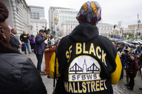 Eric McDonnell, Chair with the African American Reparations Advisory Committee (middle left) speaks at a reparations rally outside of City Hall in San Francisco, on March 14, 2023. (Jeff Chiu/AP Photo)