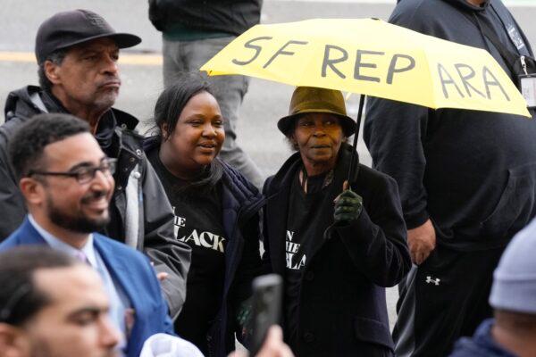 Pia Harris, with the San Francisco Housing Development Corporation, second from left, and her mother, Adrian Williams, listen to speakers at a reparations rally outside of City Hall in San Francisco, on March 14, 2023. (Jeff Chiu/AP Photo)