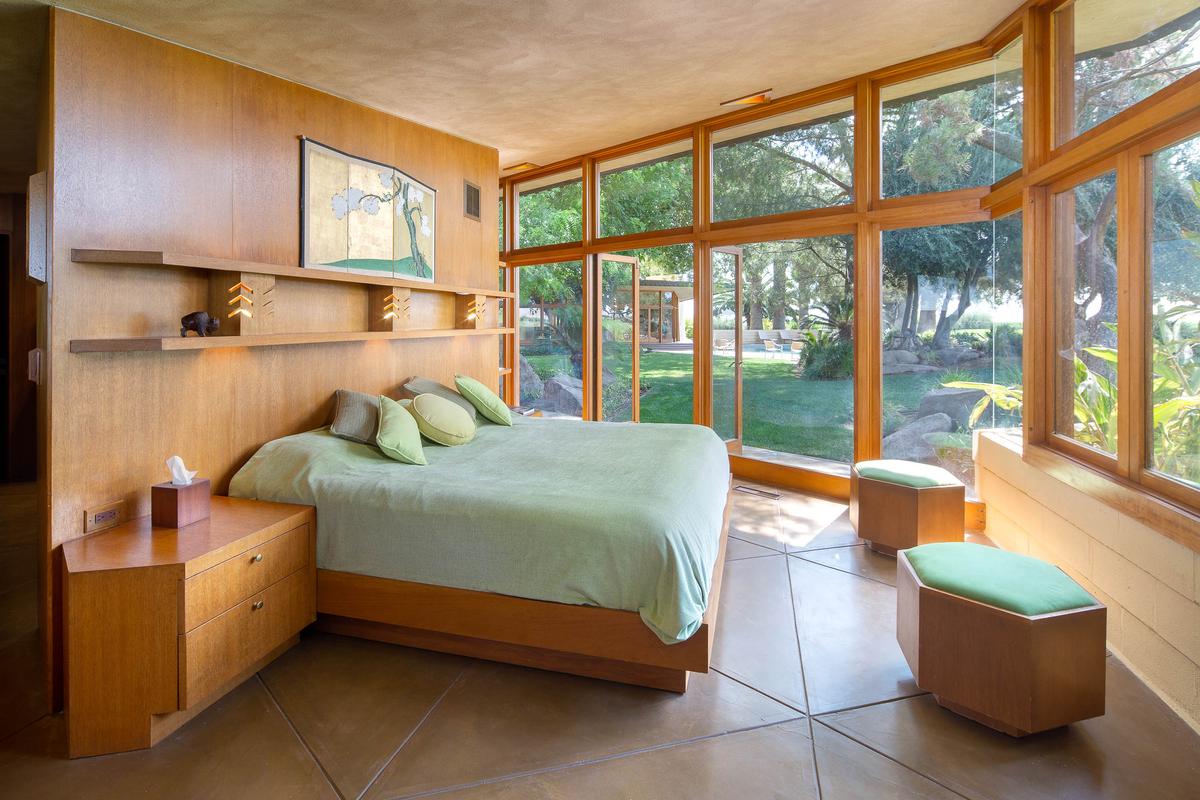 The home's warm, wood-paneled bedrooms feature large windows and glass walls that open to provide unobstructed views of and access to the pool and garden. (Courtesy of Crosby Doe)