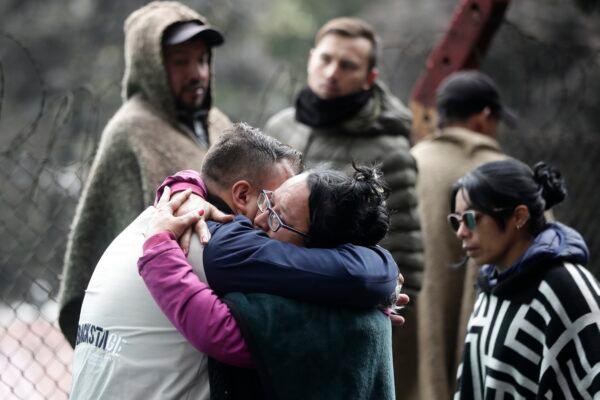 Friends and relatives of miners embrace at the entrance of a coal mine affected by an explosion that according to authorities killed at least 11 people in Sutatausa, in the Cundinamarca Province of Colombia, on March 15, 2023. (Ivan Valencia/AP Photo)