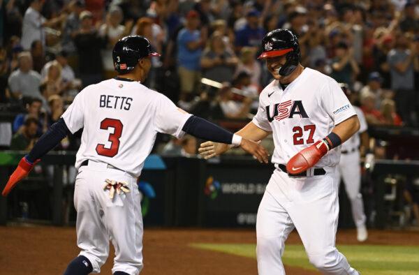 Mike Trout (27) of the United States/L.A. Angels celebrates with Mookie Betts (3), of the L.A. Dodgers, after scoring on a double by Nolan Arenado against Canada during the first inning of a World Baseball Classic Pool C game at Chase Field in Phoenix, Ariz., on March 13, 2023. (Norm Hall/Getty Images)