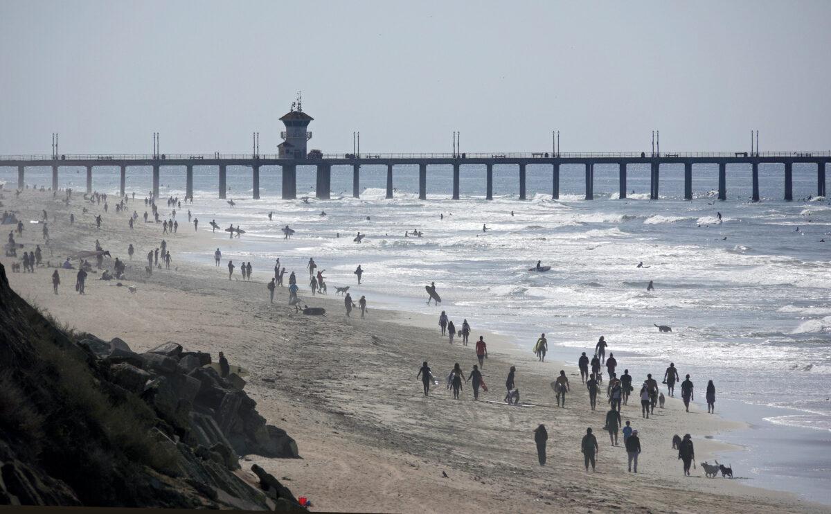 People enjoy the beach in front of the pier in Huntington Beach, Calif., on March 28, 2020. (Michael Heiman/Getty Images)