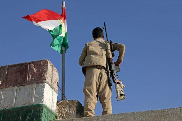 A Kurdish fighter affiliated with the Iranian Kurdistan Democratic Party (KDP–Iran) stands guard on a building following an Iranian cross-border attack in the town of Koye (Koysinjaq) in the northern Iraqi Kurdish autonomous region, on Oct. 1, 2022. (Safin Hamed/AFP via Getty Images)