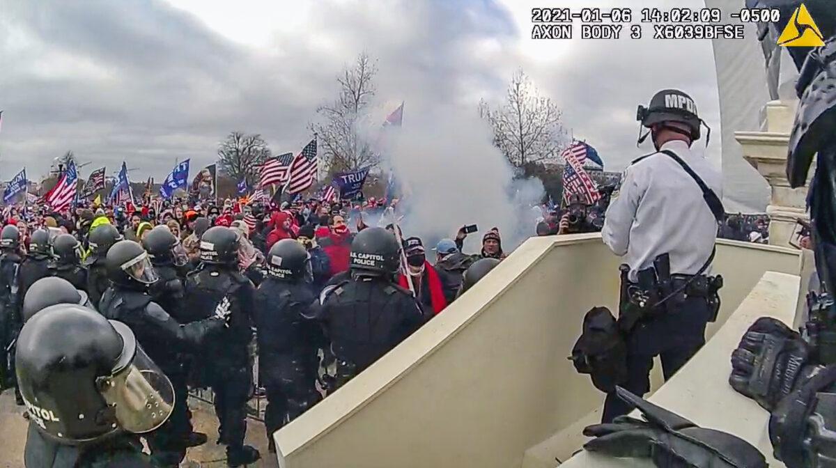 Police fire munitions into the tightly packed crowd along the barricades on the west front of the U.S. Capitol on Jan. 6, 2021. (Metropolitan Police Department/Screenshot via The Epoch Times)