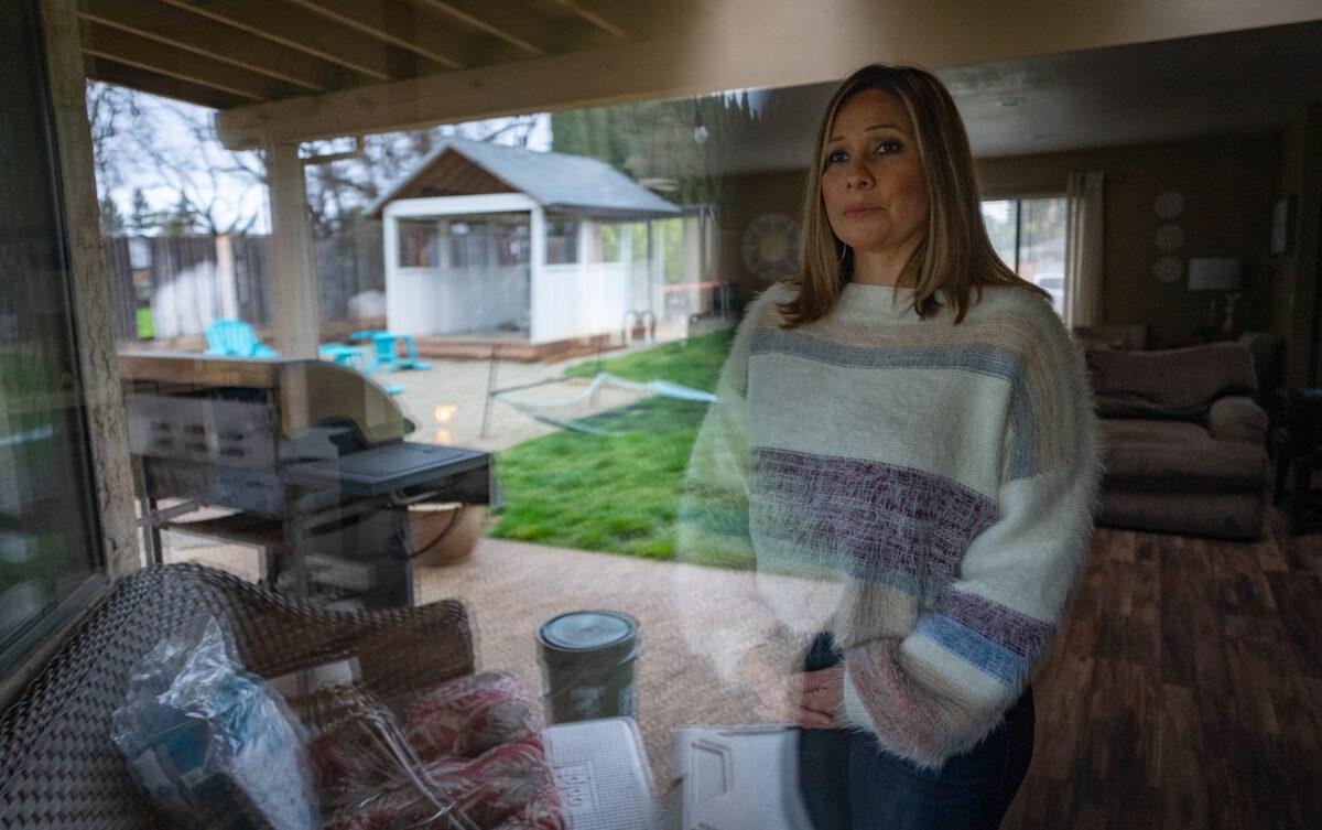 Aurora Regino looks out a window in Chico, Calif., on March 12, 2023. (John Fredricks/The Epoch Times)
