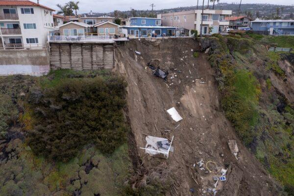 A backyard pool is left hanging on a cliffside after torrential rain brought havoc on the beachfront town of San Clemente, Calif., on March 16, 2023. (Mike Blake/Reuters)
