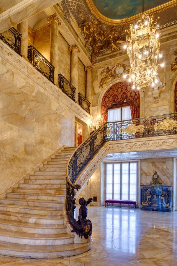 Inspired by the Palace of Versailles, the grand staircase in the Foyer was constructed of yellow Sienna marble and features an intricate wrought iron and bronze railing covered with gold. (Courtesy of The Preservation Society of Newport County)